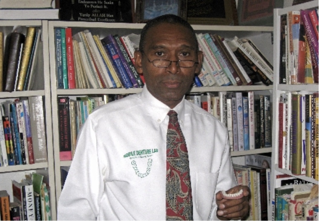 A. Shabazz, Master Denture Technologist, holding a finished denture